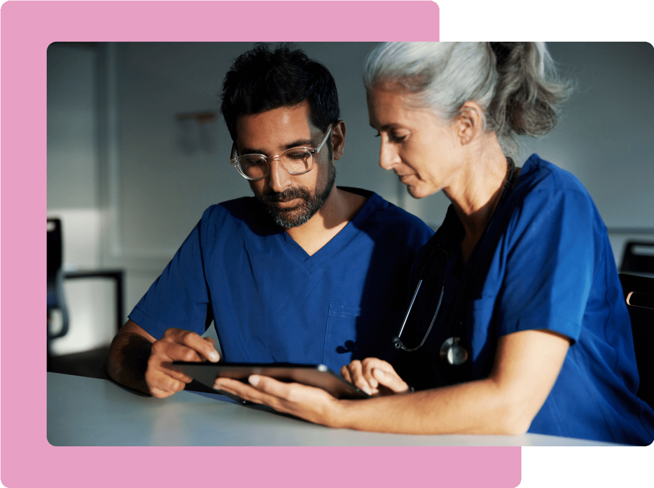 Male and female doctor looking at tablet